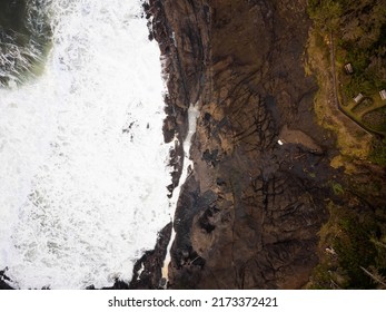 Top View Of The Ocean Shore Against Which White Foamy Waves Beat. Green Grass On The Shore. Storm, Elements, Beauty Of Nature. There Are No People In The Photo. Ecology, Geology.