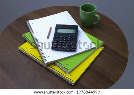Top view Office desk with calculator, pencil, blank notebook and coffee cup on round wood table background. space for text concept
