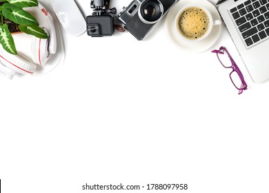 top view of office desk table with coffee cup, laptop, action camera and vintage camera isolated on white background, copy space for input text