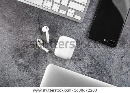 Top view Office desktop with office accessories, Desktop with business objects. metal background. Air Pods. EarPods. with Wireless Charging Case. 