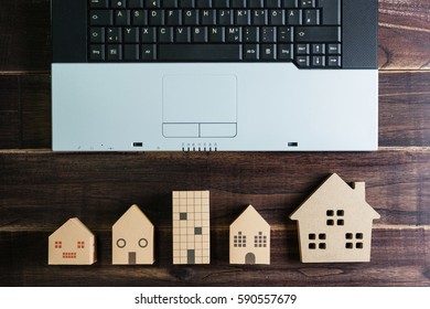 Top view of office stuff with laptop and Wooden house toy on wooden table.Concept workplace.Real estate concept, New house concept, Finance loan business concept