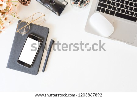 Top view office stuff with notepad, laptop and coffee cup mouse notepad shot.blank screen mobile phone and supplies on white desk work space and copy space.