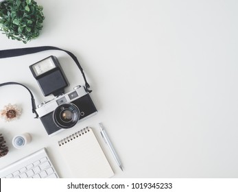 top view office table concept with retro camera, notebook and keyboard on white Color table background with copy space - Powered by Shutterstock