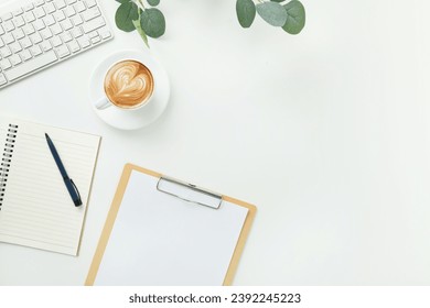 Top view office table desk workspace frame with keyboard computer, clipboard, notebook, pen and coffee cup isolated on white background. Flay lay,  ideas, notes or plan writing concept