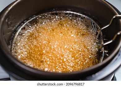 Top View. Oil Boiling In A Deep Fryer. In The Basket Of The Fryer Cook Shrimp In Batter Or Potatoes. Gadgets For The Kitchen. Cooking Seafood In Boiling Vegetable Oil.