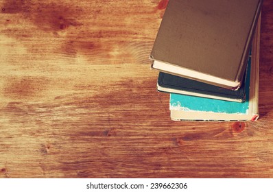 Top View Of Old Book Stack Over Wooden Table. Filtered Image