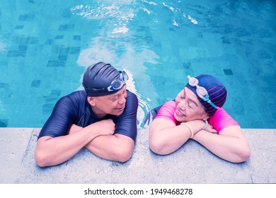 Top view of old couple wearing swimwear while chatting together on the swimming pool - Powered by Shutterstock