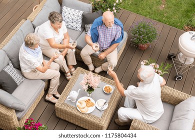 Top View Of Old Friends Reunion Outside On A Wooden Deck. Happy Seniors Making A Toast During Their Celebration.