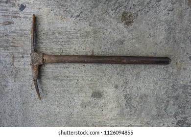 Top View Old Pick Axe Placed On A Concrete Floor.