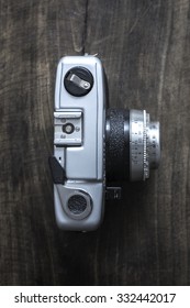 Top view of old rangefinder camera on wooden background