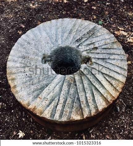 Top view of an old stone grinding wheel or millstone that once was operable in a gristmill years ago
