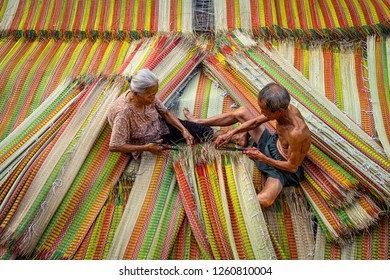 Top view of old Vietnamese lover craftsman making the traditional vietnam mats with happiness action in the old traditional village at dinh yen, dong thap, vietnam, tradition artist concept