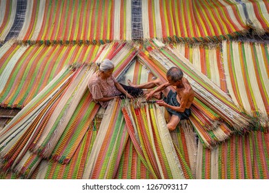 Top view of old Vietnamese lover craftsman making the traditional vietnam mats with happiness action in the old traditional village at dinh yen, dong thap, vietnam, tradition artist concept