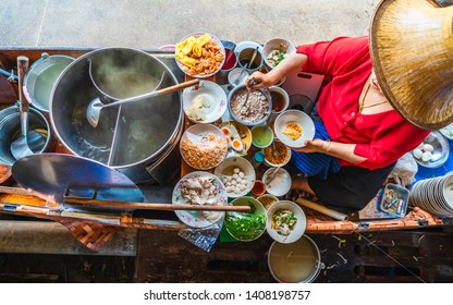 Top view old woman cooking Thai noodle soup Tom Yam style on Thai tradition boat in local floating market, Famous traditional Thai street food for tourist people travel Bangkok Thailand, Tasty Asia