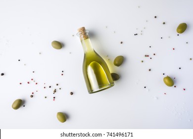 Top View Of Olive Oil Bottle With Cork And Green Olives Isolated On White