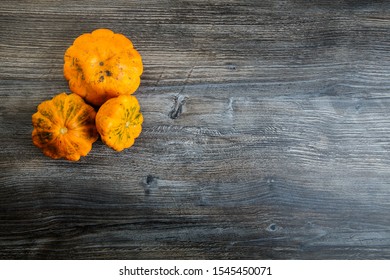 top view on assorted decorative orange pumpkins of different sizes on dark wooden table background