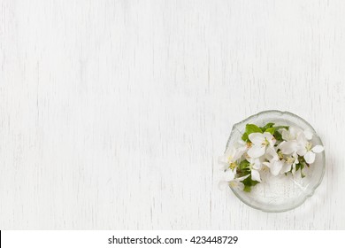 Top View On Beautiful Apple Tree Flowers In A Glass Plate On A White Wooden Background. Spring Apple Tree Blossom. White Flowers. Flat Lay. Spring Concept.