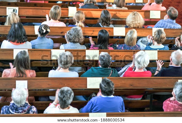 Top\
view on a Christian community at a church service or concert in a\
church - selective focus, blurred motion (hands)\
