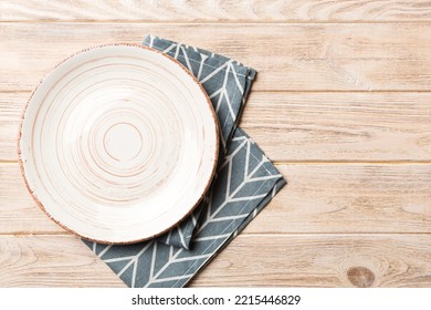 Top view on colored background empty round white plate on tablecloth for food. Empty dish on napkin with space for your design. - Shutterstock ID 2215446829