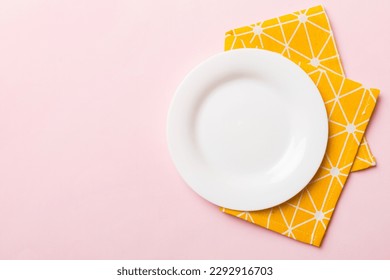 Top view on colored background empty round white plate on tablecloth for food. Empty dish on napkin with space for your design.