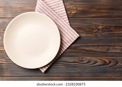 Top view on colored background empty round white plate on tablecloth for food. Empty dish on napkin with space for your design. - Powered by Shutterstock