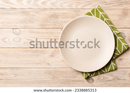 Top view on colored background empty round white plate on tablecloth for food. Empty dish on napkin with space for your design.
