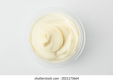 Top view on a cup of mayonnaise on white background. Sauce commonly used in sandwiches, hamburgers, composed salads, and on French fries