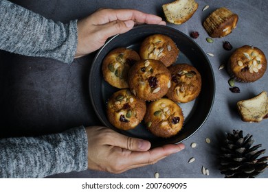 Top view on the dining table with hands holding a muffin plate to set on the table.