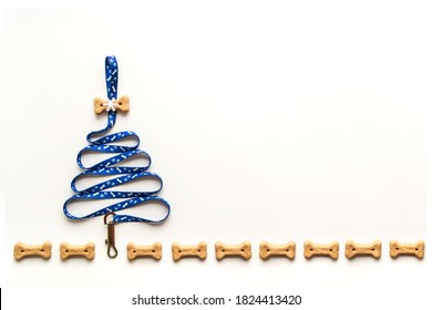 Top View On Dog Supplies. Snacks And Leash In A Form Of Christmas Tree. Greeting Postcard With Copy Space. Pet Shop Concept, Isolated On White Background