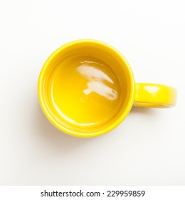 Top View On Empty Yellow Coffee Or Tea Mug Or Cup. Studio Shot From Above On White Background.