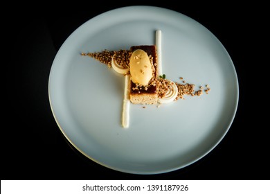 top view on gluten-free baked dessert with ice cream and white mousse served against black background