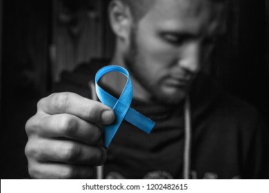 Top View On Hands Holding Prostate Cancer Ribbon, Colon Cancer Concept, Blue Ribbon Symbol.black And White.