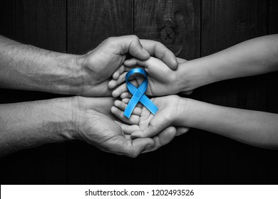 Top View On Hands Holding Prostate Cancer Ribbon, Colon Cancer Concept, Blue Ribbon Symbol.black And White.