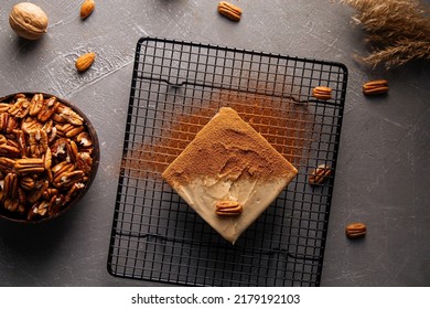 Top view on healthy sugarless cake with pecan nuts on grey background