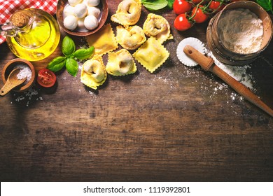 Top view on homemade pasta ravioli on old wooden table with flour, basil, tomatoes and vintage kitchen accessories - Powered by Shutterstock