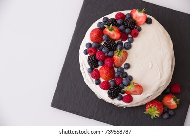 Top View On Homemade Vanilla Birthday Cake Decorated With Berries: Strawberries, Blueberries, Raspberries On Black Board. Celebration, Party Cake. 