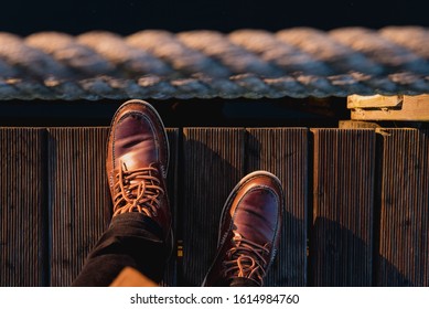 Top view on male legs in brown boots standing on a wooden bridge background. - Powered by Shutterstock