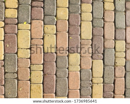 Top view on multicolor paving stone road. Old pavement of granite texture. Street cobblestone sidewalk. Abstract background for design.