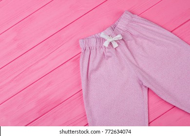 Top View On Pajama Pants. Fine Pink Pattern And White Waist Drawstring. Cute Bottom Garment For Sleeping And Lounging.