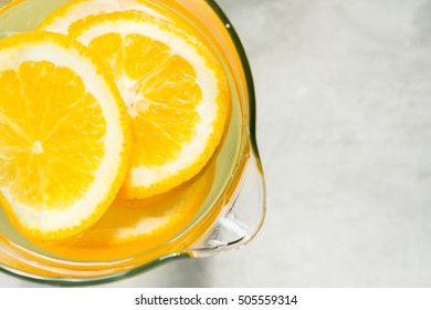 Top View On A Pitcher With Aromatic Water From Orange Slices, Space For Text