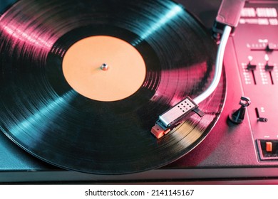 Top view on retro vinyl record player playing music from LP album.