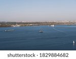 Top view on the river and cityscape . Ferry boats, barges and cargo ships sailing on water. Daytime riverscape  image.