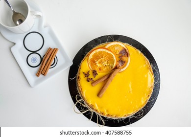 top view on round cheesecake on table with cinnamon rolls on plate with rings pattern and empty cup with spoon