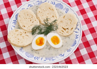Top view on the rustic vintage blue onion porcelain plate with traditional Czech bread dumplings in dill sauce and boiled egg. Fresh, healthy, seasonal example of traditional recipe of Czech cuisine.