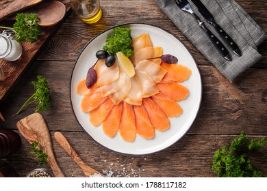 Top view on smoked fish platter appetizer on the wooden table