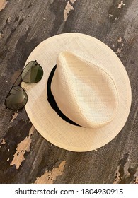 Top view on Thai traditional hat handmade by palm leaves and modern sunglasses on antique wooden background