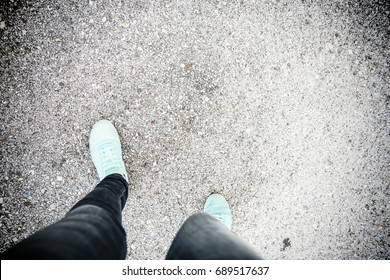 Top view on a touristic legs  wearing light blue-green shoes staying on the road  walking go to dream.Looking down on feet
