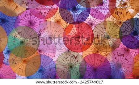 Top view on the traditional colored Chinese sunshade umbrellas. Beautiful Traditional Chinese patterns and ornaments on the colorful wooden and paper umbrellas. Lunar Year decoration.