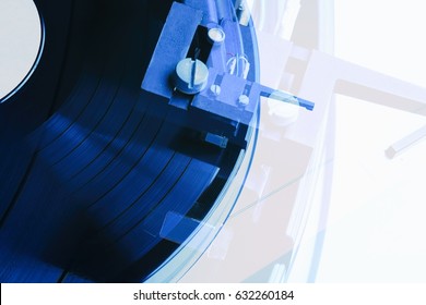 Top View On Turntable Playing Vinyl Record.Party Dj Turntables Needle On Disc With Music.Turntables Overhead Shot In Double Exposure.Dark Blue Color.Hifi Needle Cartridge In Focus.Turn Table Top View