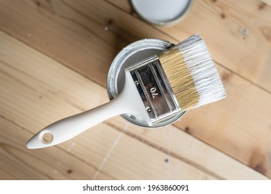 Top View On White Paint Brush On The Opened Can On The Wooden Table Or Floor Painting And Renovation Repairing Concept